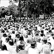 A large crowd wearing white sitting on the Plaza of the America during a Vietnam War protest in 1972