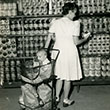 Woman buy canned goods with baby in shopping cart